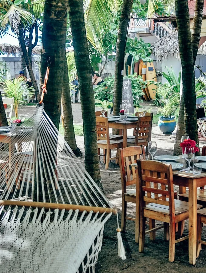 Terraza de Bomalu con hamacas y mesas frente al jardín